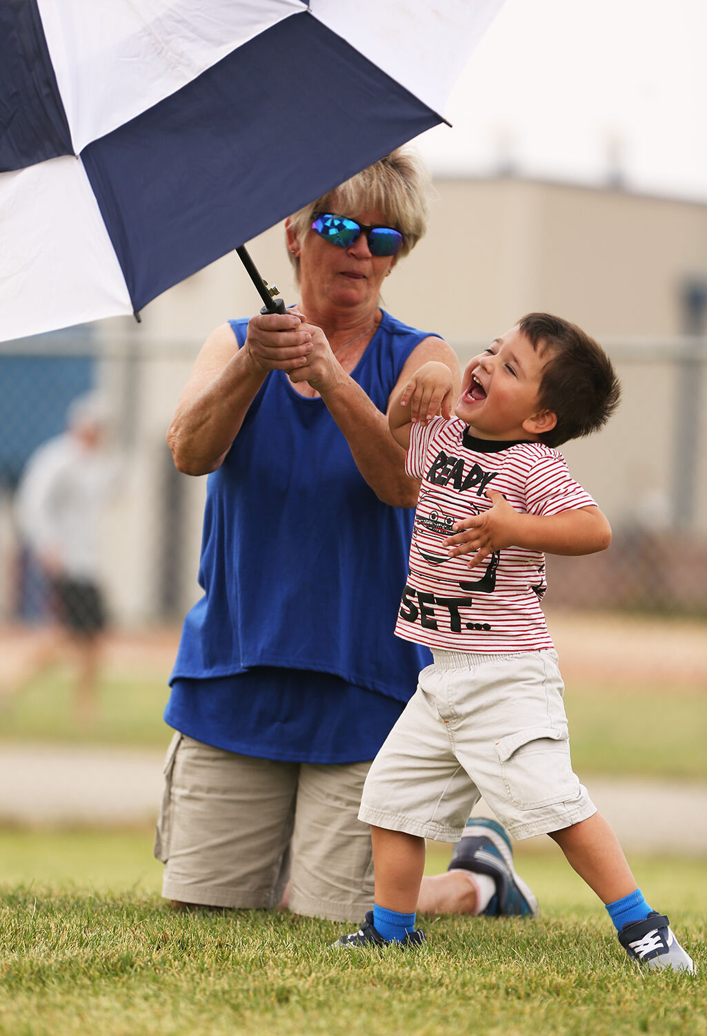 Evander Largent bursts out in laughter as his great grandmother Jan Gray opens the umbrella